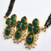Long mangalsutra with four-stranded black beads, peacock design pendant with pearl border, and matching earrings